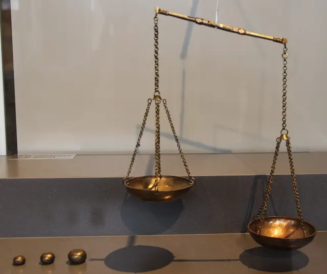 Viking-age brass folding balance scale with small weights, used to weigh silver