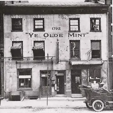 Old photograph of the first US Mint building on Seventh Street in Philadelphia, a three-story brick front with a "Ye Olde Mint 1792" sign