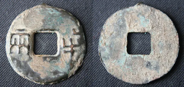 Both sides of a Qin dynasty ban liang bronze coin, about 30 mm across, with a square hole, two Chinese characters on the front and a plain back