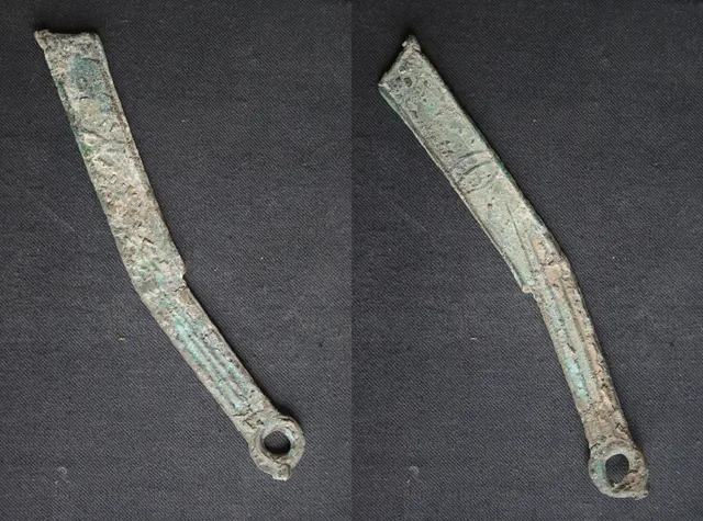 Both sides of a slim, slightly curved bronze "ming" knife coin from the state of Yan, with a ring at the end of the handle