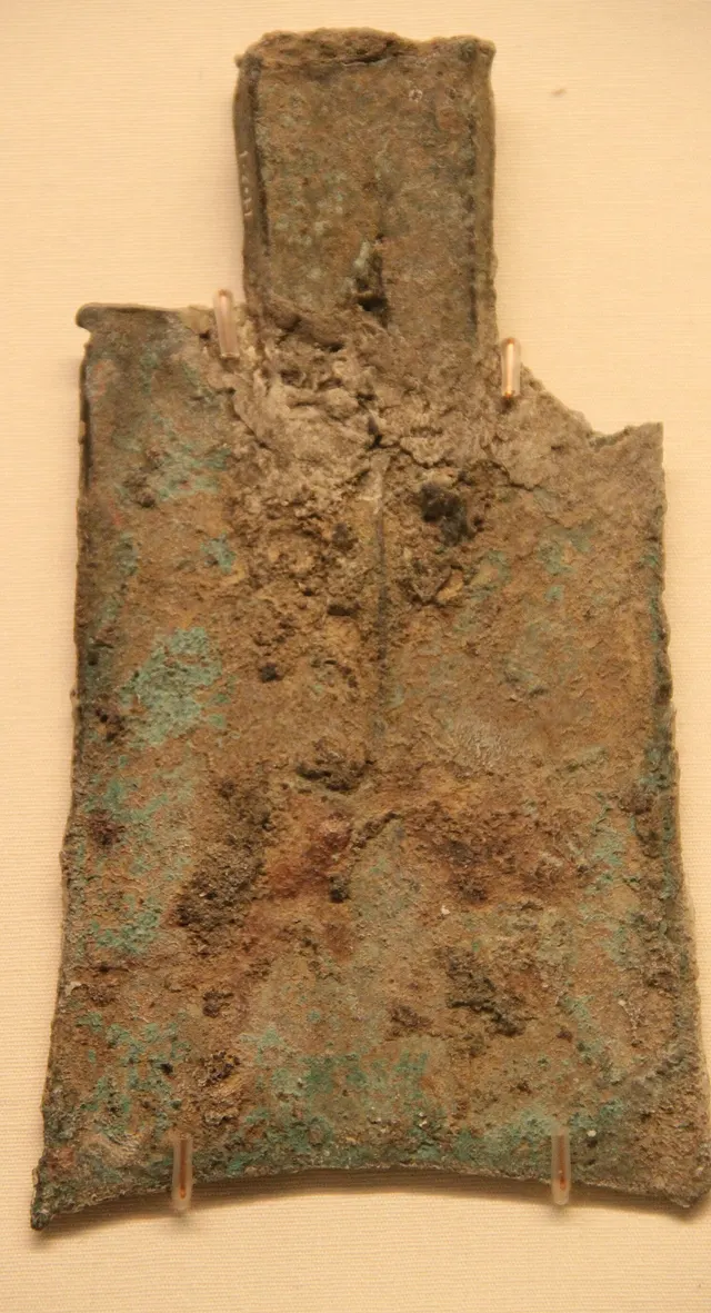 Early Chinese hollow-handled spade coin in corroded bronze, with a square socket at the top where a handle would fit