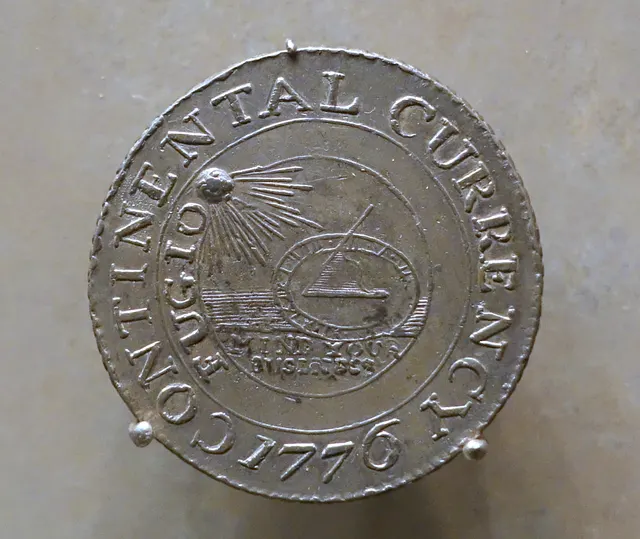 Pewter 1776 Continental Currency dollar showing a sundial under the sun with the word FUGIO