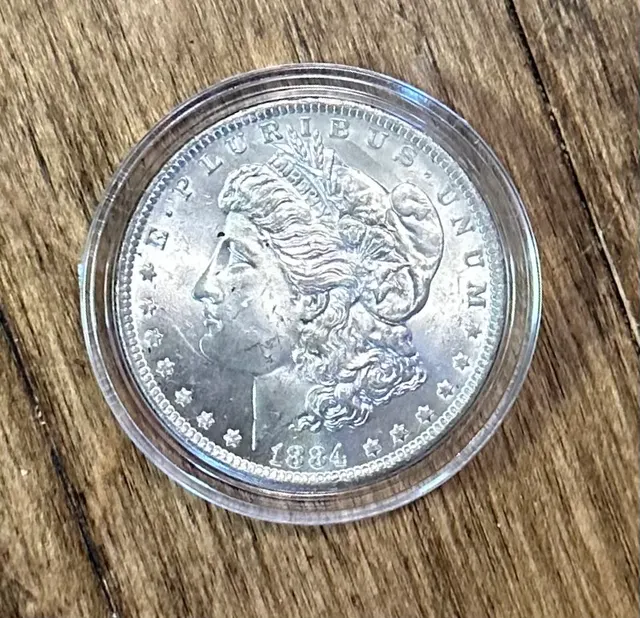 An 1884 Morgan silver dollar sealed in a clear round plastic coin capsule