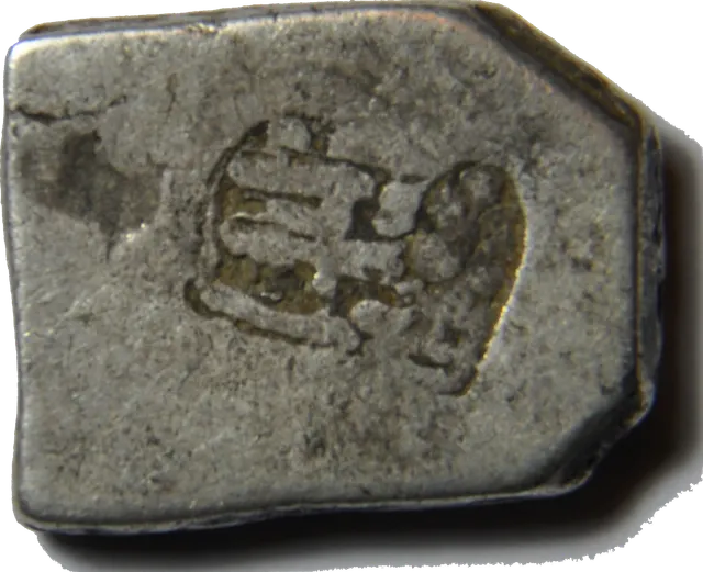 The back of the same karshapana: a plain face with one small banker's mark