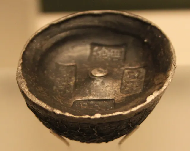 A rounded Ming-dynasty silver ingot dated 1552, with stamped characters on its top surface