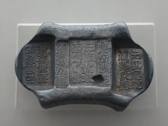A saddle-shaped Qing silver ingot from Yunnan stamped with the shop's name and two public assayers' marks